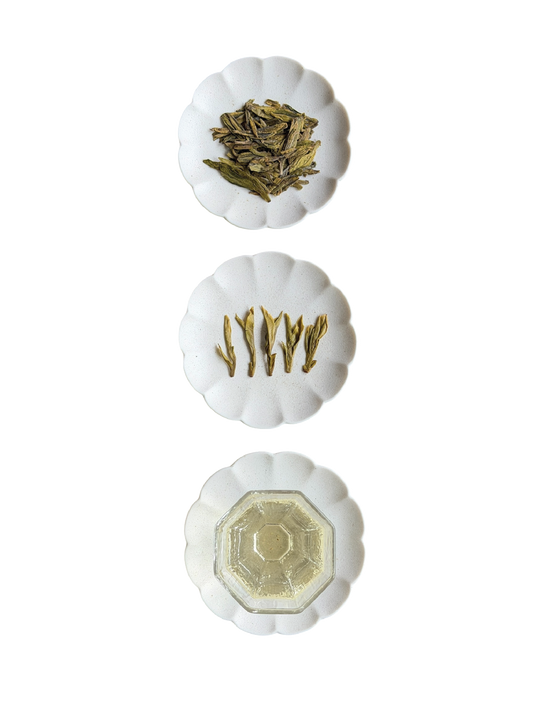Three white scalloped ceramic dishes arranged vertically. The top dish shows the signature flat dry leaves, the middle dish shows wet leaves consisting of long buds, and the bottom dish shows the infusion.