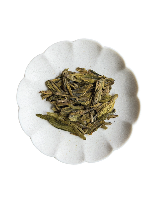 The signature flat and yellow green dried tea leaves from the pan-firing process of Longjing. They are made out of first flush green tea which is the first harvest in Spring.